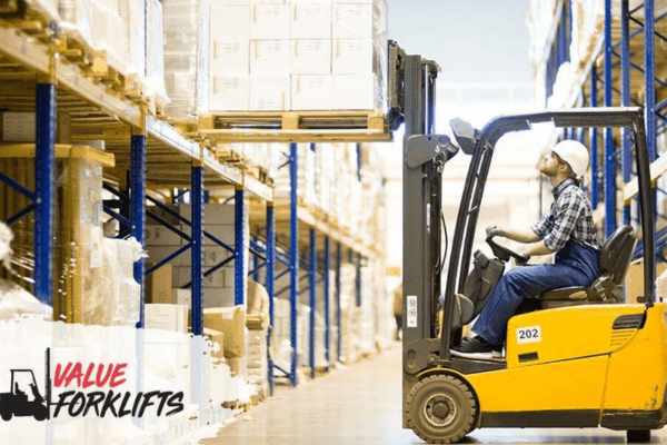 A man operating a forklift inside a warehouse, surrounded by shelves and boxes, highlighting warehouse logistics.