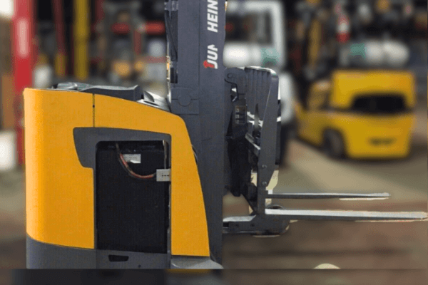 A parked forklift in a warehouse, showcasing its robust design and readiness for material handling tasks.